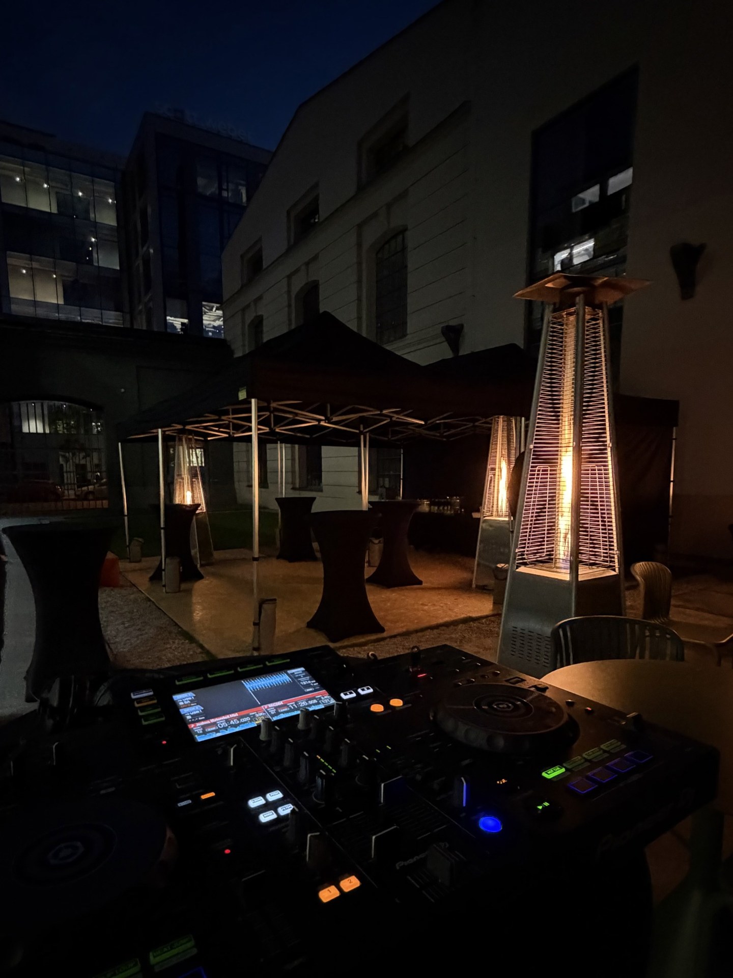 DJ decks and a warmly lit outdoor setting for BBQ & Beats