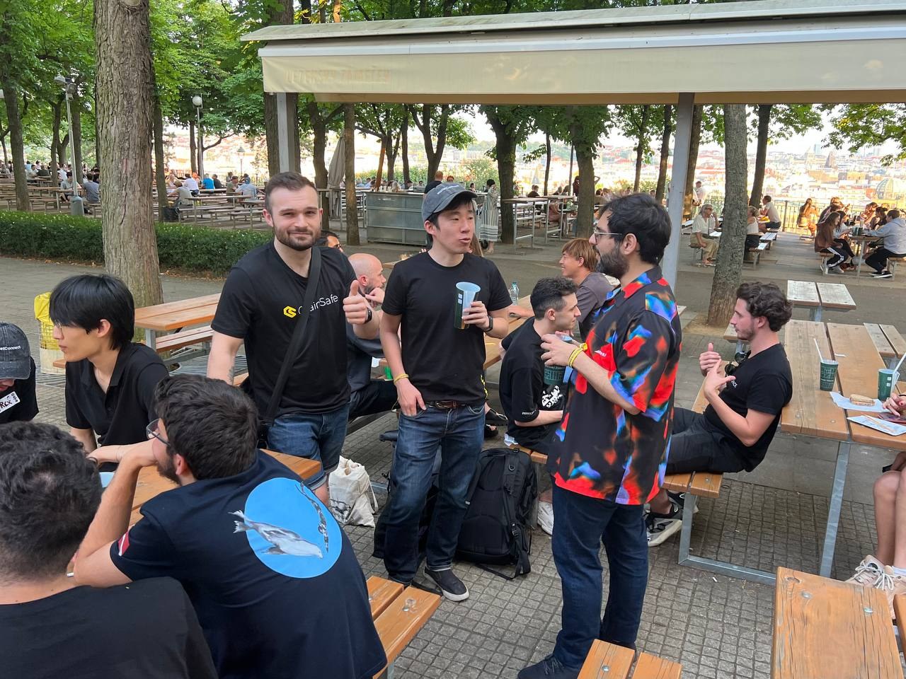 Members of the Prague Web3 community talking around outdoor tables